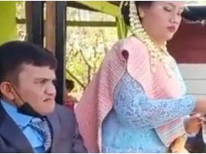 Berita viral dan trending: Seorang pria pendek yang berjalan menggunakan tingkat menikah wanita cantik yang lebih tinggi darinya.