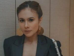 Kenakan baju rajut dengan punggung terbuka saat menggendeong seorang bayi, Wulan Guritno disebut sebagai hot mom.