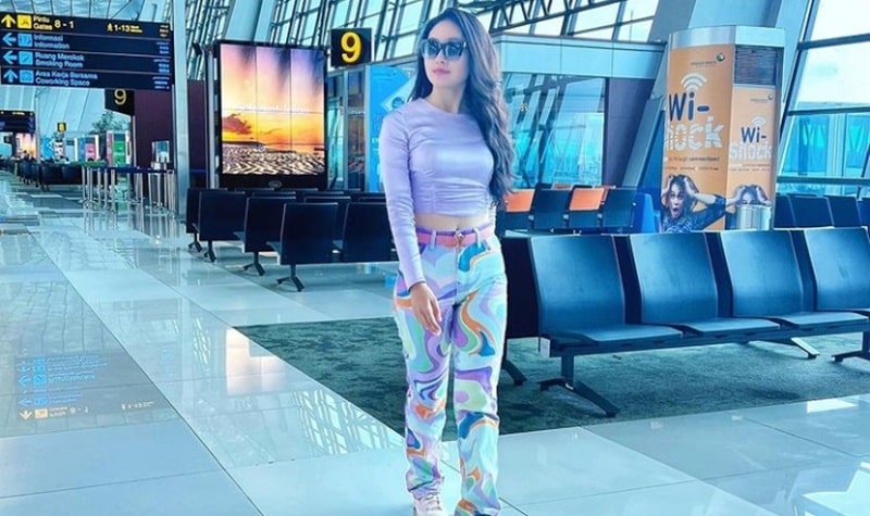 Potret Natasha Wilona saat di bandara dengan style ala cewek kue menarik perhatian. Ia tampil dengan outfit yang hampir semua berwarna ungu.  