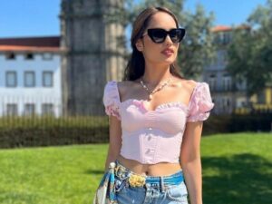 Cinta Laura kenakan crop top model Sabrina warna merah muda dan celana pendek ramai dipuji netizen, disebut terlihat tidak nyata.
