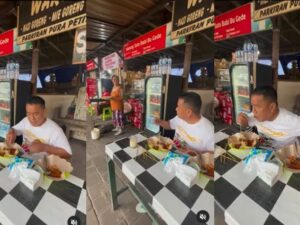 Hotman Paris makan sate di pinggir jalan, netizen malah salfok pada tulisan spanduk bermerek sate babi yang ada di belakangnya.