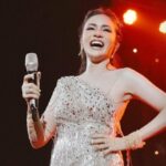 Cekricek.id – Momo Geisha memamerkan potret dirinya saat menyanyi di atas panggung suatu acara yang mengundangnya. Pada acara perayaan anniversary dari salah satu brand kecantikan itu, dia tampil dengan setelan gaun mini dengan rumbai-rumbai yang memenuhi drai pinggang hingga ke lutunya.