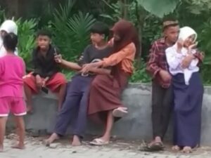 Empat pasang bocah di bawah umur saling bermesraan di tepi jalan sembari bermain ponsel, bahkan ada yang nekat membuka hijabnya.
