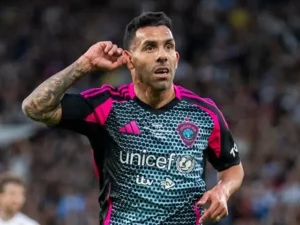 Carlos Tevez menunjukkan bekas luka di leher saat bermain untuk Manchester City, simbol perjuangan hidupnya dari masa kecil hingga menjadi bintang sepak bola dunia