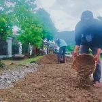 Pekerja DPUPR Padang melakukan penambalan jalan berlubang dengan aspal