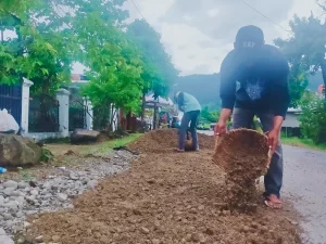 Pekerja DPUPR Padang melakukan penambalan jalan berlubang dengan aspal