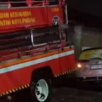 Tim pemadam kebakaran Kota Padang mengevakuasi mobil yang masuk parit di Jalan Raya Jundul