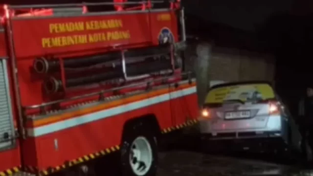 Tim pemadam kebakaran Kota Padang mengevakuasi mobil yang masuk parit di Jalan Raya Jundul