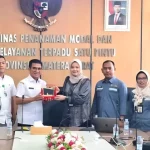 Kepala DPMPTSP Sumbar menyerahkan cendera mata kepada perwakilan DPMPTSP Riau (Foto: DPMPTSP Sumbar)