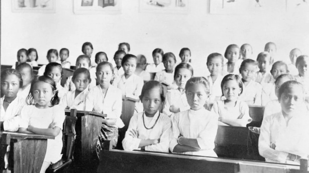 Murid perempuan duduk di bangku kelas Sekolah Kartini pada masa kolonial