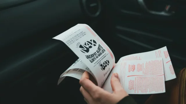 Sepasang tangan memegang lembar kupon undian berhadiah