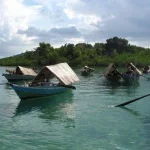 Sejumlah sampan beratap kajang milik Orang Suku Laut mengapung di perairan dangkal Kepulauan Riau