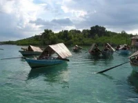 Sejumlah sampan beratap kajang milik Orang Suku Laut mengapung di perairan dangkal Kepulauan Riau