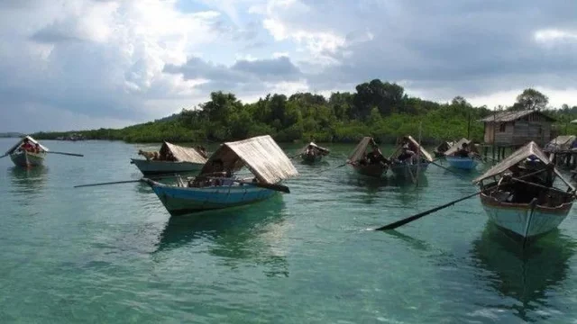 Sejumlah sampan beratap kajang milik Orang Suku Laut mengapung di perairan dangkal Kepulauan Riau