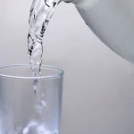 Air dituangkan dari ceret ke dalam sebuah gelas bening