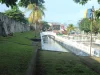 Tembok batu Benteng Oranje di Ternate dengan halaman rumput di depannya