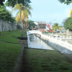 Tembok batu Benteng Oranje di Ternate dengan halaman rumput di depannya
