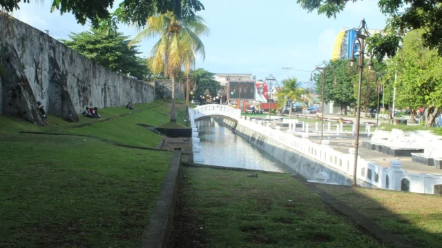 Tembok batu Benteng Oranje di Ternate dengan halaman rumput di depannya