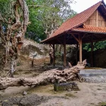 Bangunan cungkup beratap sirap berdiri di tengah pepohonan tua di kompleks Makam Ratu Mas Malang
