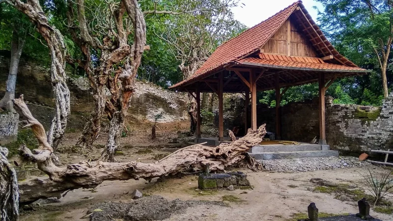 Bangunan cungkup beratap sirap berdiri di tengah pepohonan tua di kompleks Makam Ratu Mas Malang
