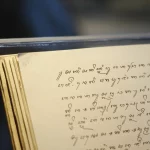 Halaman naskah beraksara Jawa terbuka di dalam lemari pamer museum