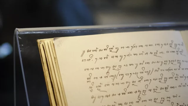 Halaman naskah beraksara Jawa terbuka di dalam lemari pamer museum