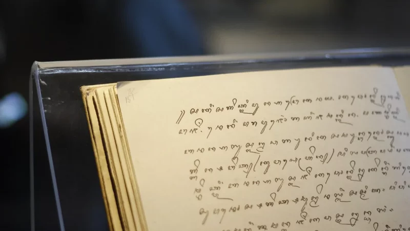 Halaman naskah beraksara Jawa terbuka di dalam lemari pamer museum
