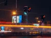 Papan-papan iklan menyala di persimpangan jalan kota pada malam hari