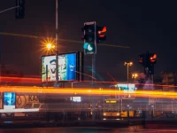 Papan-papan iklan menyala di persimpangan jalan kota pada malam hari
