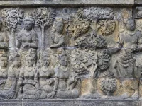 Panil relief batu Borobudur memuat banyak sosok manusia duduk berjajar di bawah pohon