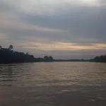 Permukaan Sungai Batanghari yang lebar dengan cahaya senja