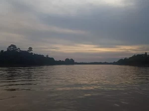 Permukaan Sungai Batanghari yang lebar dengan cahaya senja
