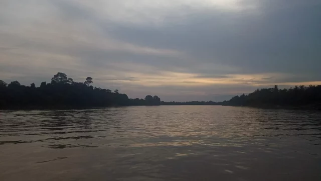 Permukaan Sungai Batanghari yang lebar dengan cahaya senja