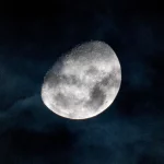 Bulan bersinar di balik lapisan awan tipis pada langit malam