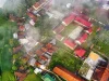Pemandangan udara perkampungan beratap merah yang tertutup kabut tipis