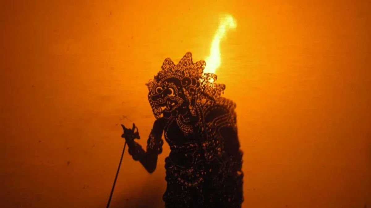 59 Kesalahan Terjemahan Naskah Tarsan Wanara Seta 2 Layar pertunjukan wayang kulit dengan siluet tokoh dan cahaya lampu