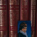 Deretan jilid kitab Risale-i Nur berjajar di rak dengan potret kecil di depannya