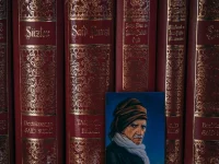 Deretan jilid kitab Risale-i Nur berjajar di rak dengan potret kecil di depannya