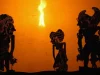 Siluet tokoh kera dalam pertunjukan wayang kulit di depan layar