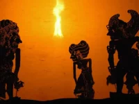 Siluet tokoh kera dalam pertunjukan wayang kulit di depan layar