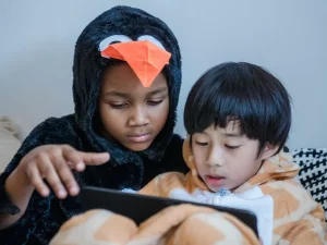 Dua anak menonton tayangan di layar tablet