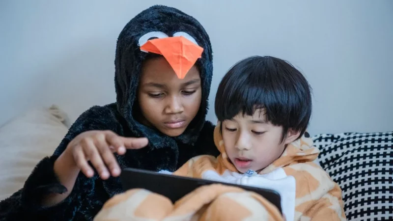 Dua anak menonton tayangan di layar tablet