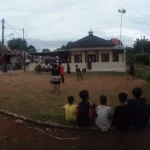 Pemain berebut bola dalam pertandingan sepak bola di lapangan kampung