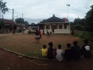 Pemain berebut bola dalam pertandingan sepak bola di lapangan kampung