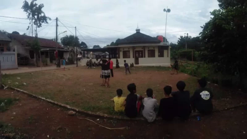 Pemain berebut bola dalam pertandingan sepak bola di lapangan kampung