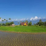 Hamparan sawah dengan bangunan beratap gonjong dan perbukitan di latar belakang, Kabupaten Agam