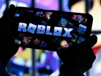 Seorang anak memainkan Roblox lewat telepon pintar