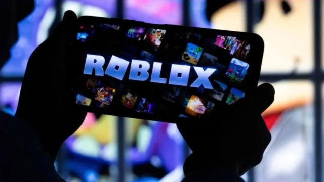 Seorang anak memainkan Roblox lewat telepon pintar