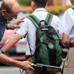 Guru memeriksa tas murid dengan detektor logam di sebuah sekolah di Bangkok