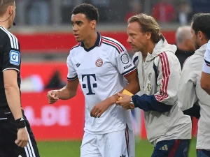 Jamal Musiala meninggalkan lapangan didampingi ofisial Bayern Munich. [Foto: Getty Images]